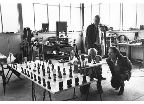 Maurizio Calvesi, Consagra e Augusta Monferrini guardano il progetto di allestimento della mostra "Pietro Consagra" alla Galleria Nazionale d'Arte Moderna di Roma. Studio dell'artista, Roma, 1989. Foto E. Aricò.